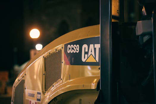Close-up of a road roller at night highlighting machinery details and urban lighting.