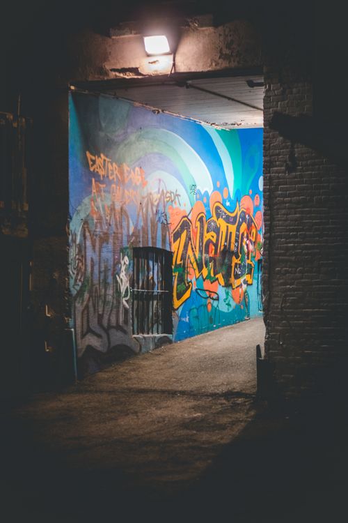 Free Colorful graffiti artwork in a dimly lit alleyway, showcasing street art culture. Stock Photo