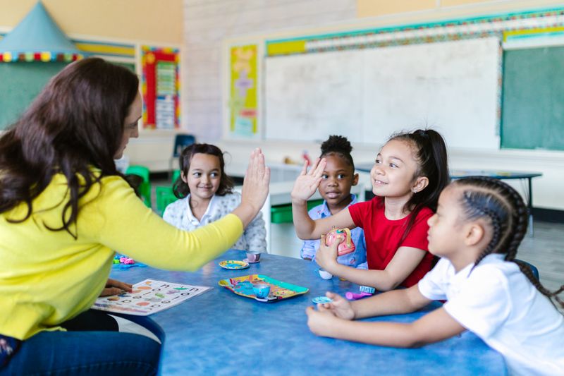 Teacher and student sharing a high five in the classroom