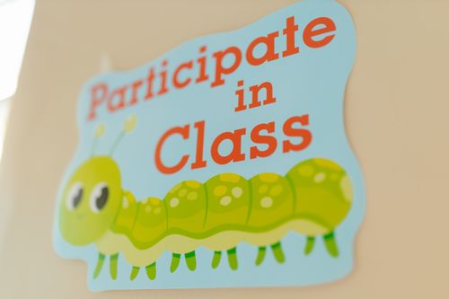 Free A brightly colored sign encouraging class participation featuring a cute caterpillar design. Stock Photo