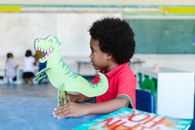 A Boy Holding a Dinosaur Cutout