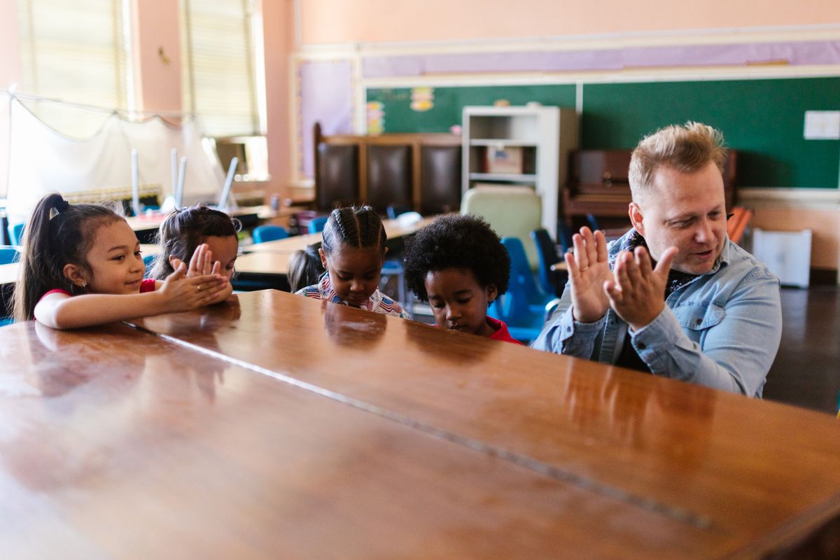 Docente y niños participando en una actividad musical de aula