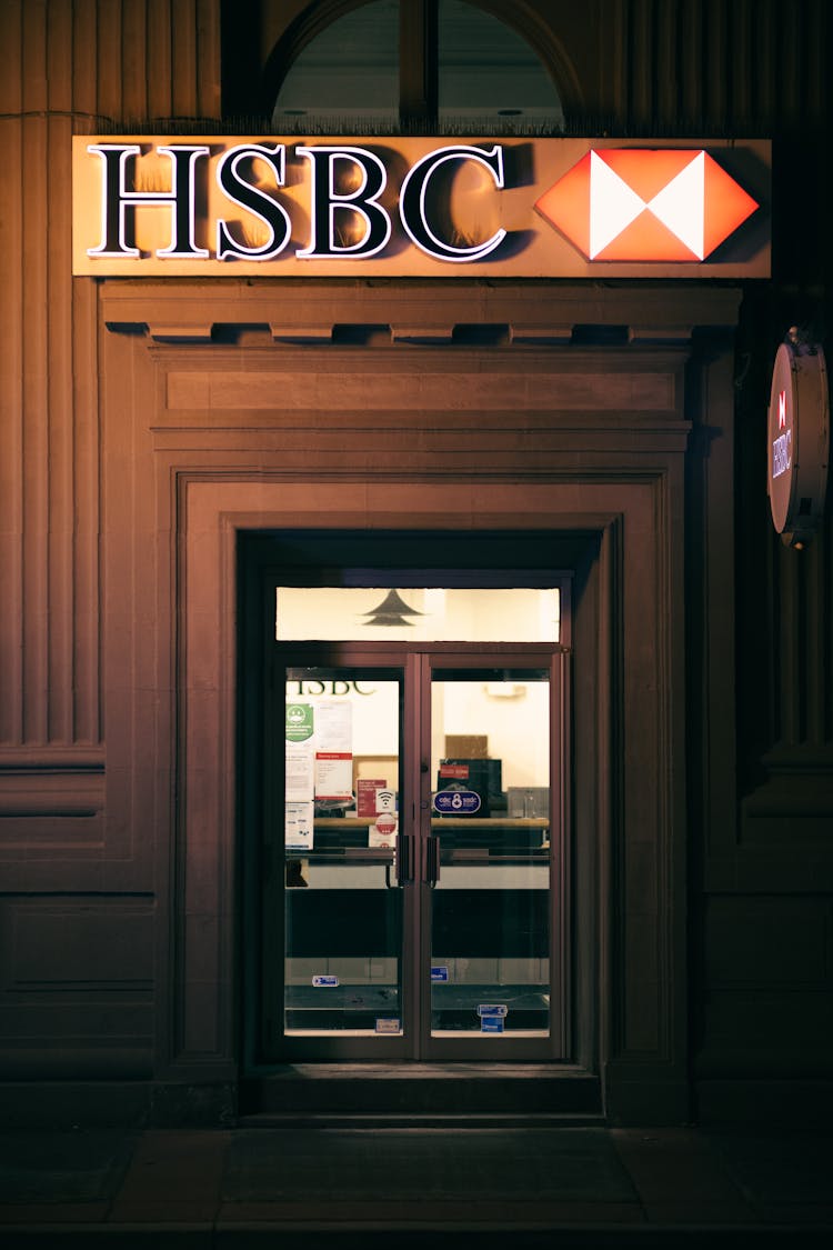 Sign Above Entrance To The Bank At Night 