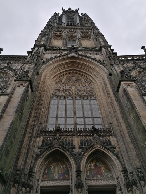 Free A stunning low-angle view of a Gothic cathedral facade featuring intricate arches and large windows. Stock Photo