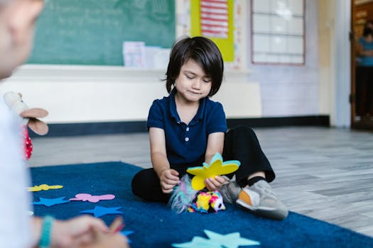 Young child focused on craft activity in a school classroom with colorful paper butterflies.