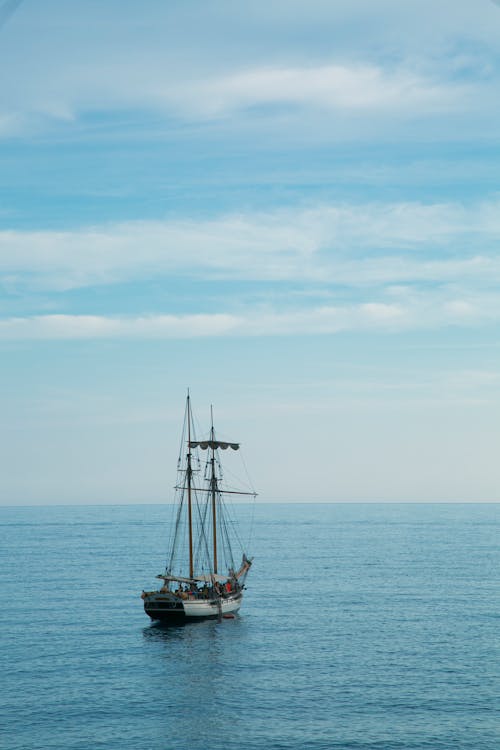 Brown Ship Sailing on Sea Under Blue Sky