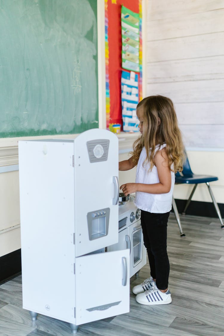 Little Girl Playing With Play Kitchen 