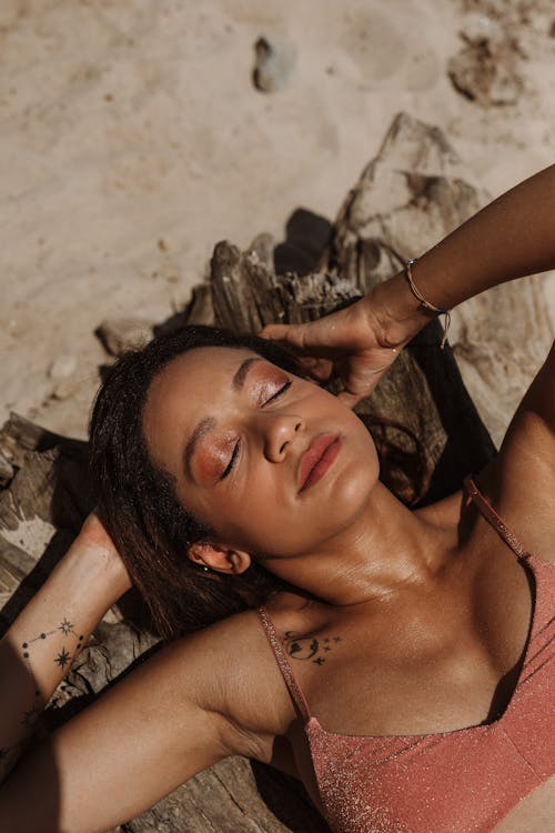 Free Woman in Black and White Bikini Lying on Brown Sand Stock Photo