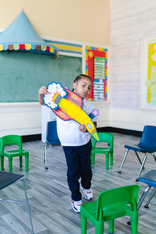 Free Boy Playing with a Toy Inside the Classroom Stock Photo