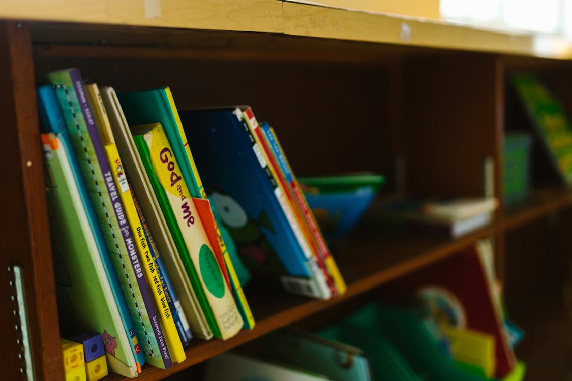 Free Books on Brown Wooden Shelf Stock Photo