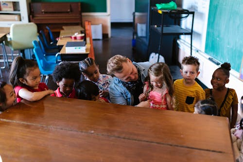 Children Sitting in Front of Brown Wooden Table