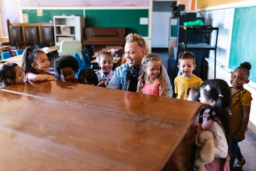 A Teacher Speaking Surrounded by His Students