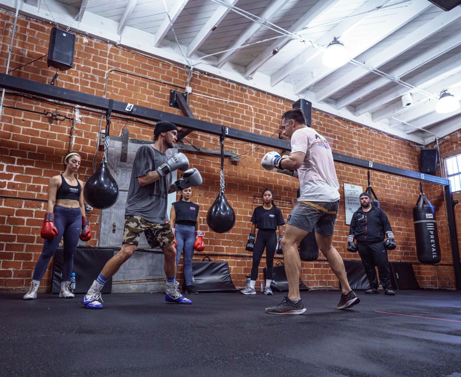 Cours collectif de boxe : démonstration technique devant un groupe dans une salle