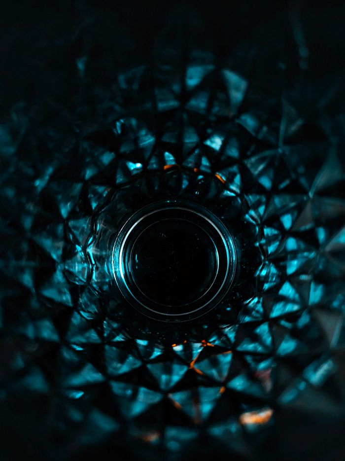 Faceted glass photographed head-on in low blue light — photo by Andre Moura on Pexels