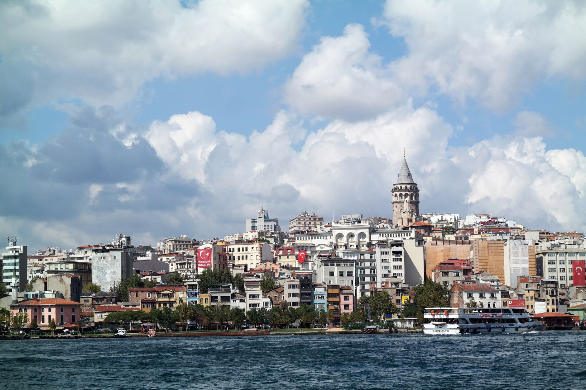 Panoramic cityscape of Istanbul with the iconic Galata Tower and vibrant architecture along the waterfront.