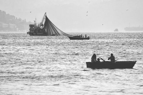 Free Black and white image of fishing boats sailing in Istanbul's waters, showcasing local fishery activities. Stock Photo