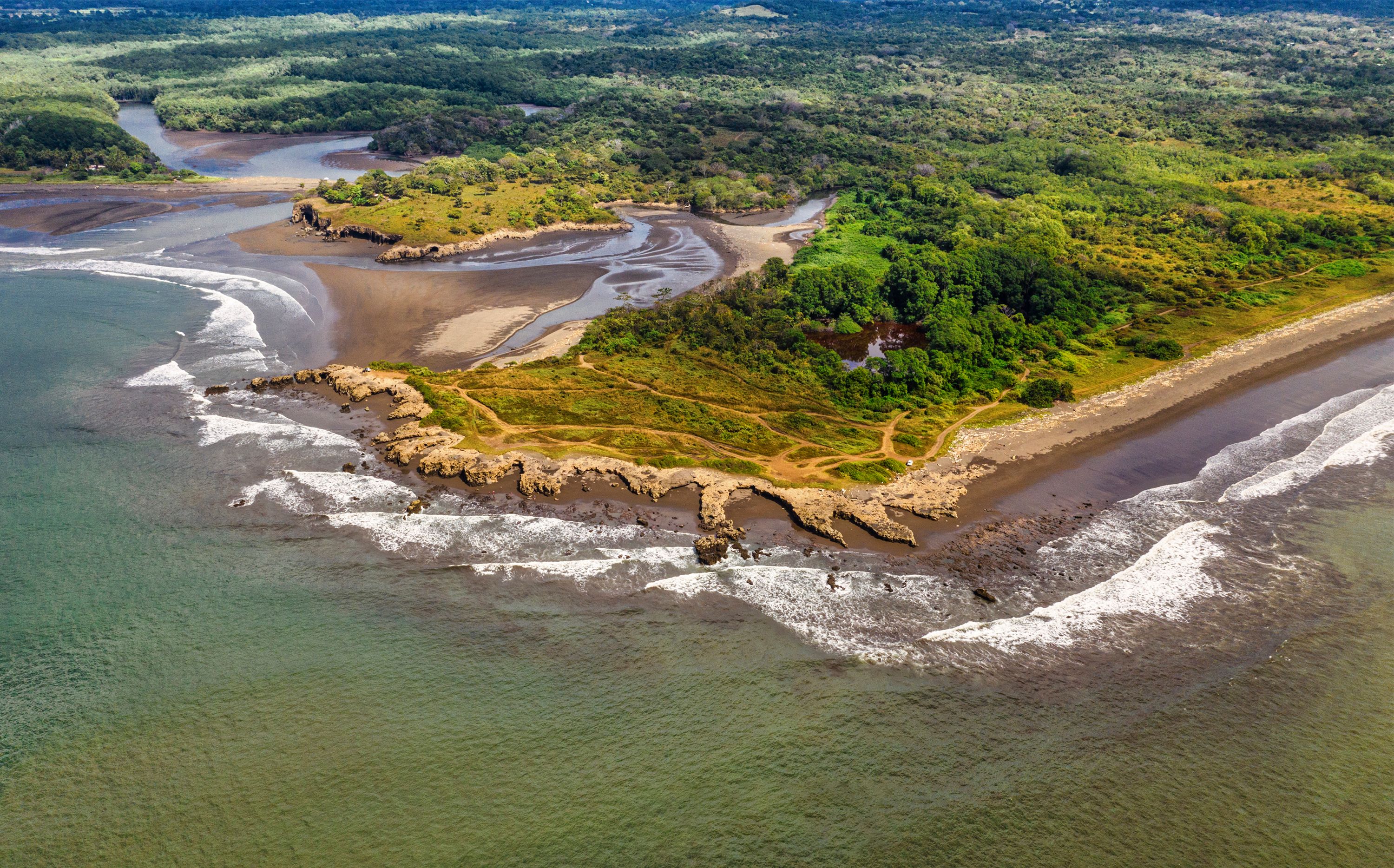 Vista aérea de una propiedad costera en Costa Rica con palmeras y agua azul del océano