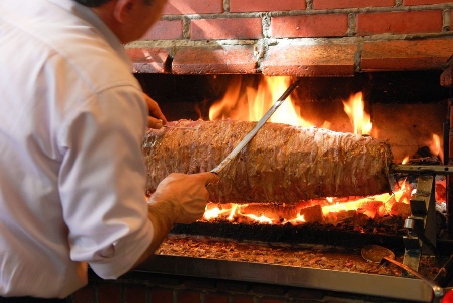 Virėjas prie atviros ugnies kepa kebabo mėsą — kebabinės virtuvė Radviliškyje