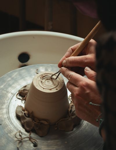 Artisan shaping a clay mug on a pottery wheel, by Aedrian Salazar on Pexels