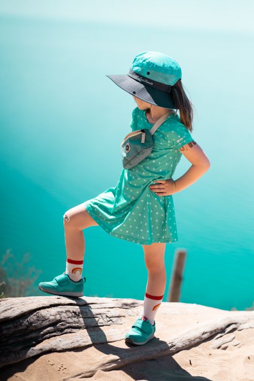 Free A fashionable girl poses confidently on a rock, enjoying a bright sunny day outdoors. Stock Photo