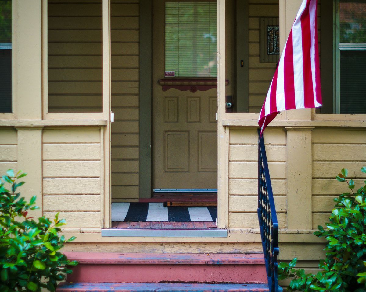 House entrance with an American flag and greenery.