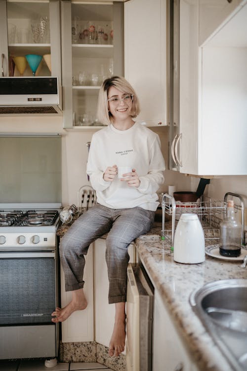 A Woman Sitting on the Kitchen Counter