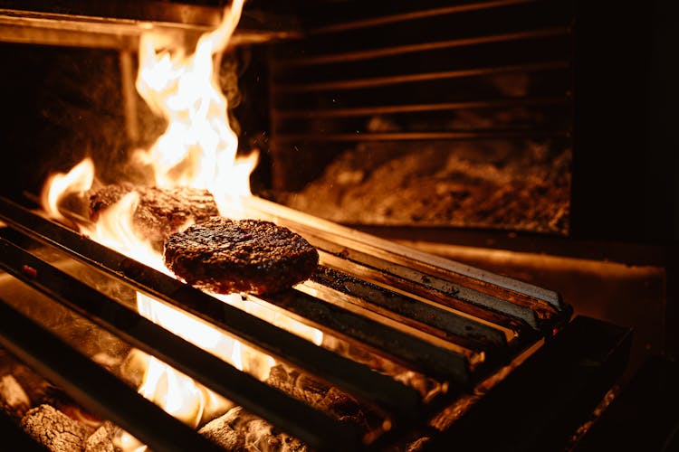 Burger Patty On Griller With Fire