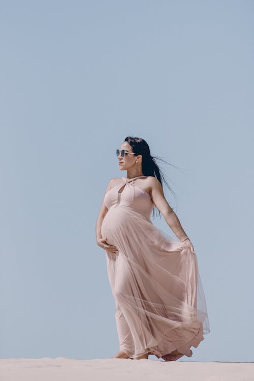 Бесплатное стоковое фото с бежевое платье, беременная, ветреный