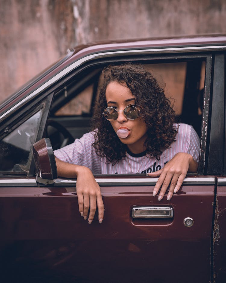 Woman Sitting In The Car Playing With Bubble Gum