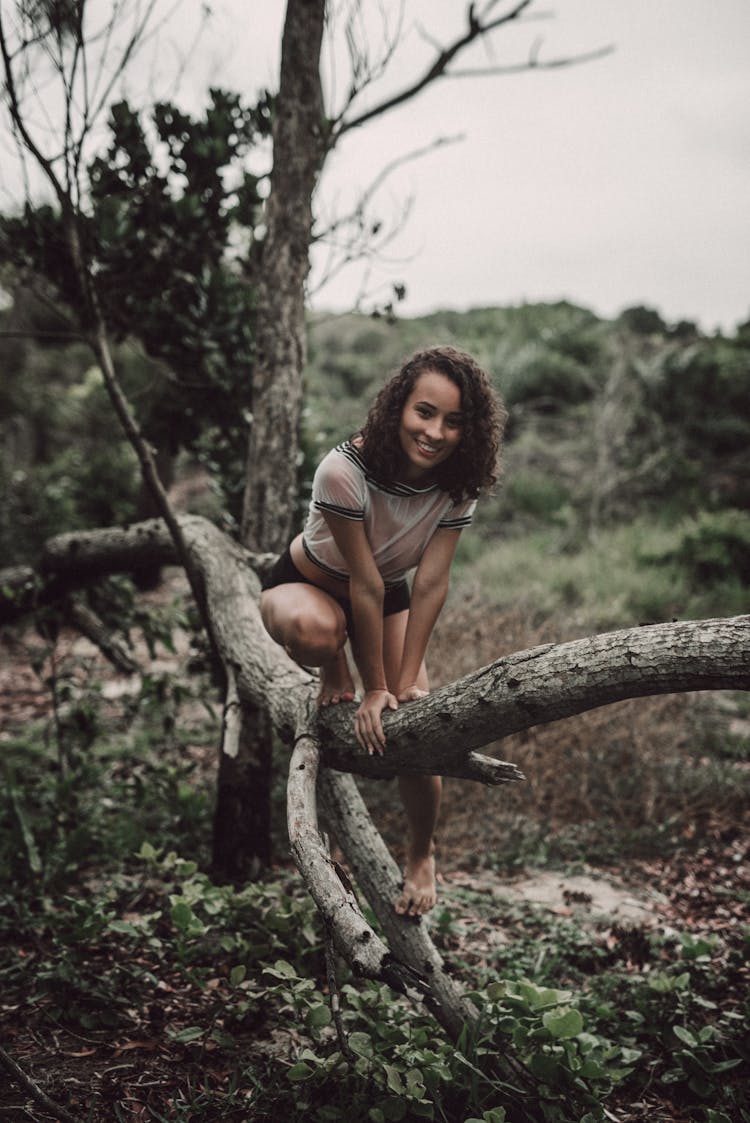 Woman Climbing On A Tree Branch