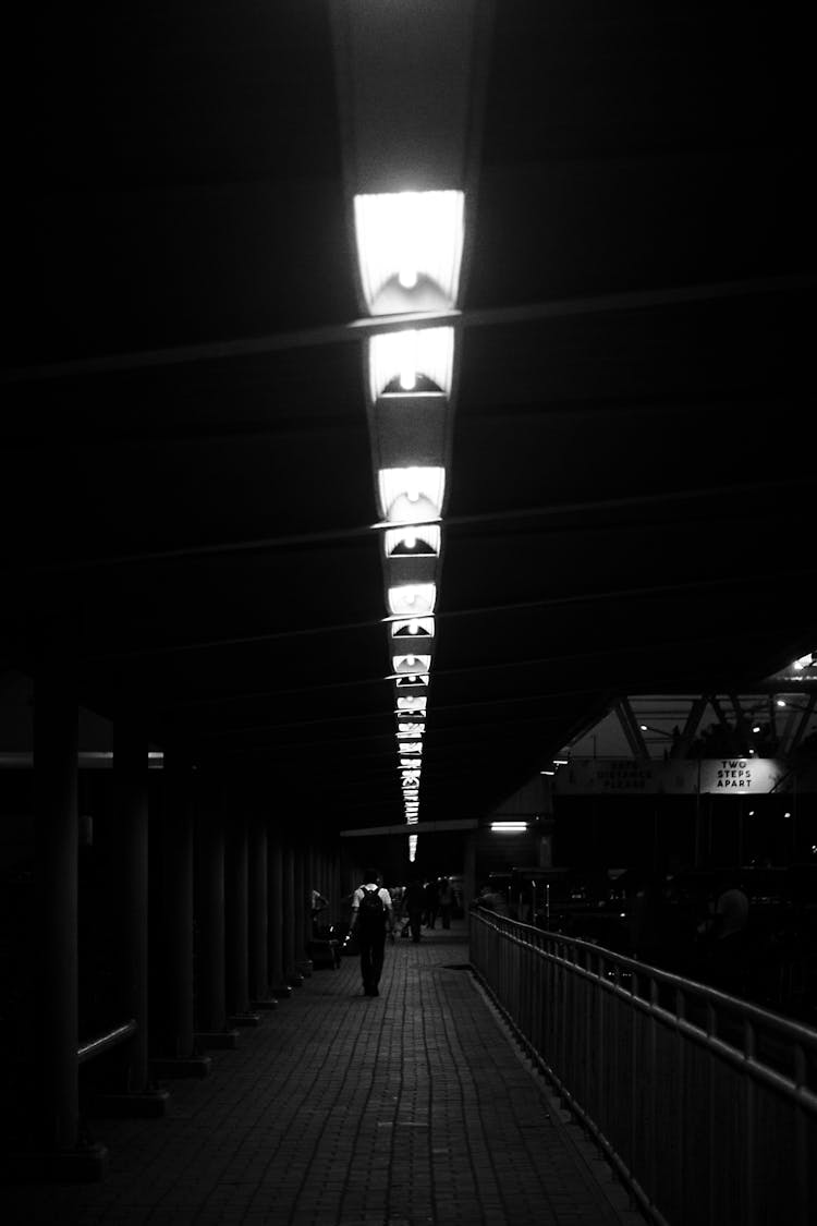 People Walking Tunnel In Darkness