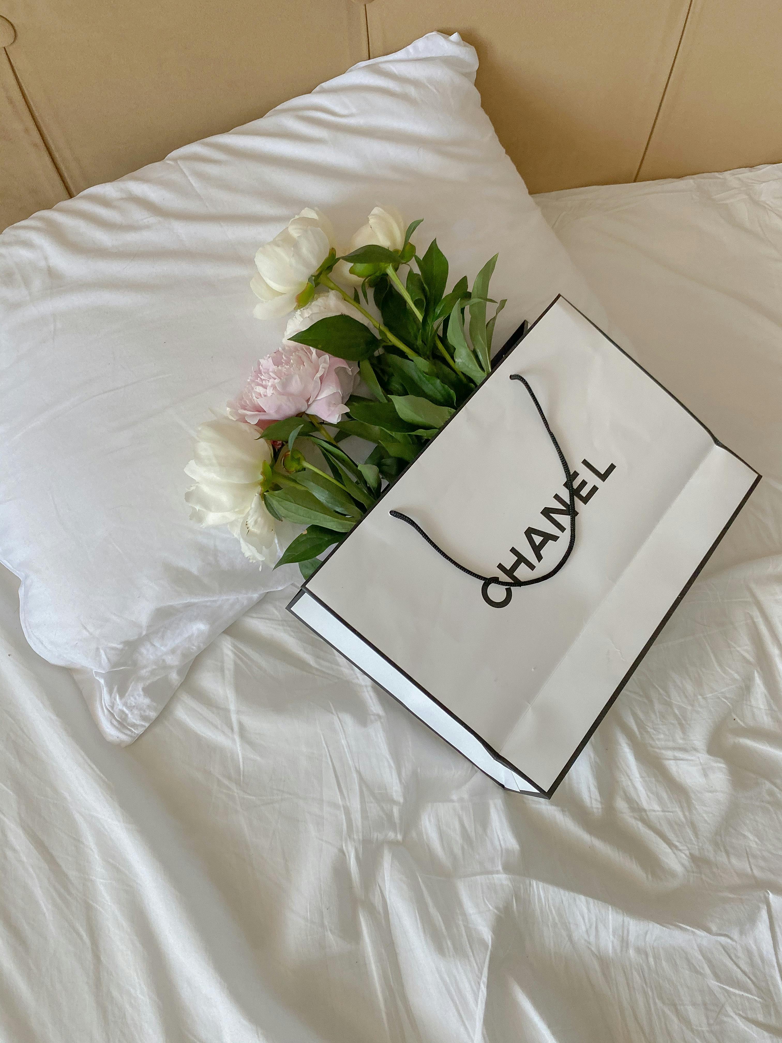 A Beautiful Flowers on a Chanel Paper Bag · Free Stock Photo