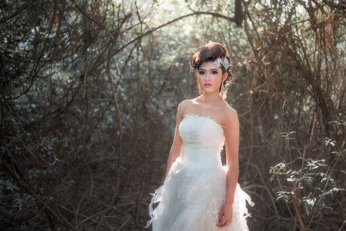 Free Beautiful woman in a white bridal gown amidst a forest background. Stock Photo