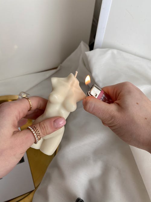 Close Up Shot of a Person Lighting Candle with a Lighter