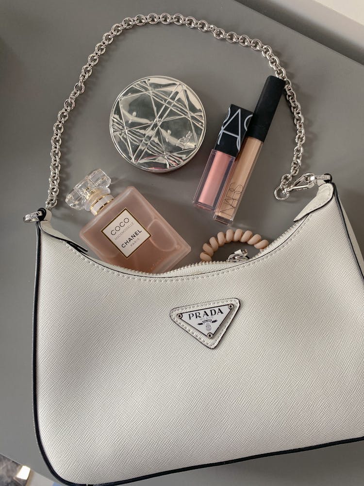 Flatlay Shot Of A Bag With Makeup And Perfume