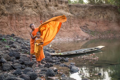 Two Boys Wearing Kasaya while Standing on a Rocky Shore