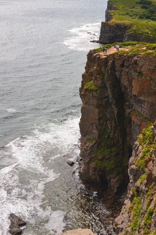 People Standing at the Edge of a Costal Cliff