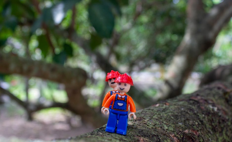 Colorful LEGO figure on tree branch, blending creativity with nature.