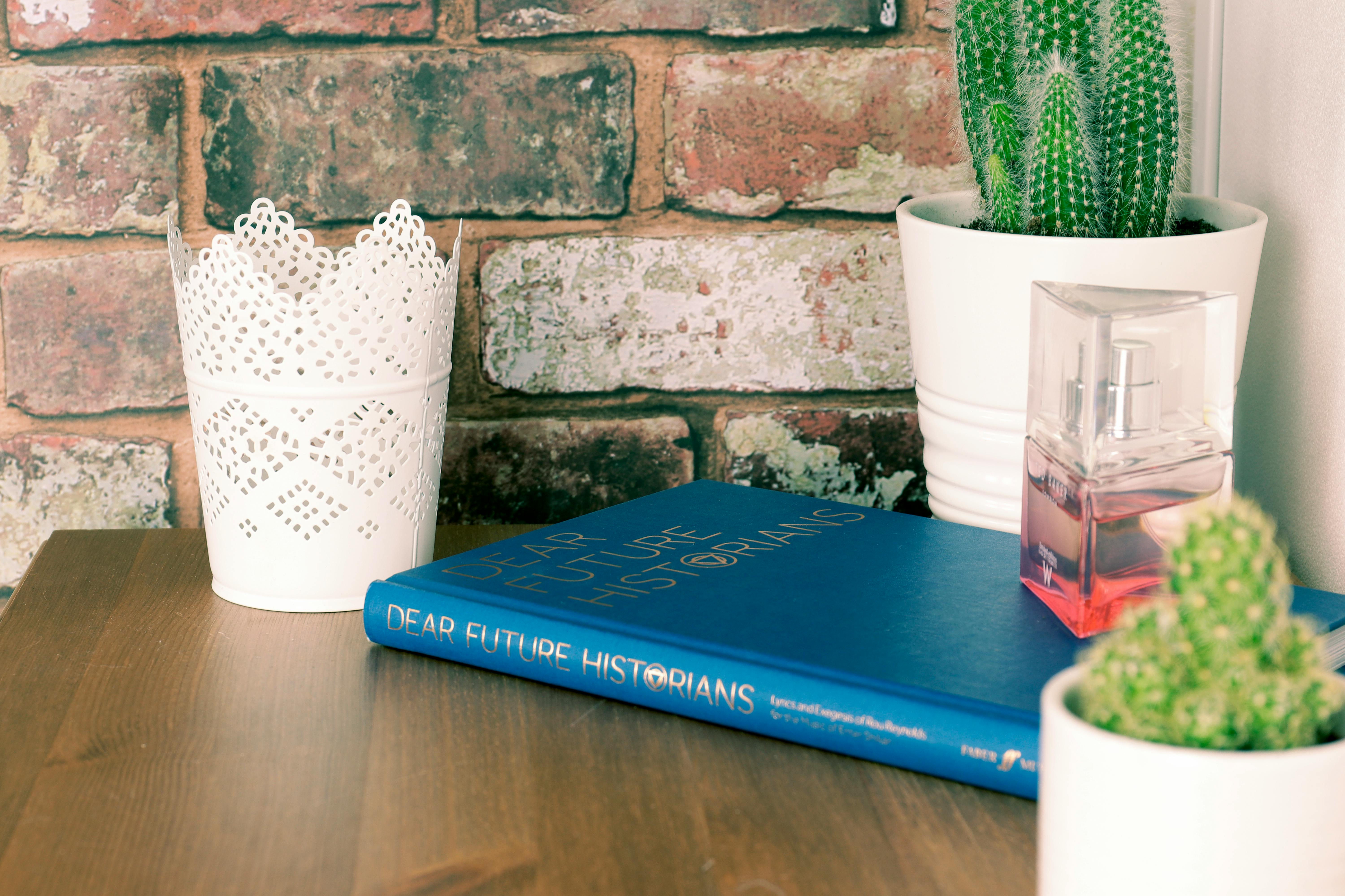 blue book on brown wooden table with flower vases