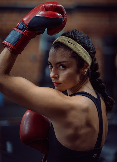 Ethnic sportswoman in boxing gloves looking at camera