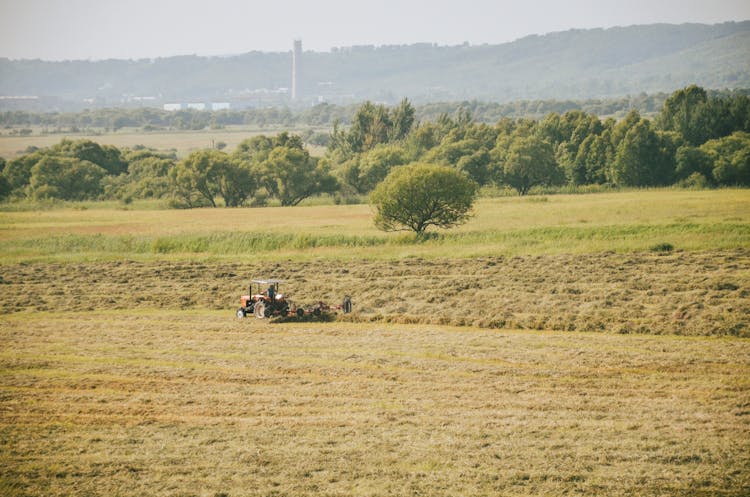 A Tractor Harvesting On The Field