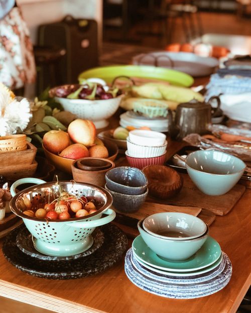 Free A vibrant arrangement of kitchenware, ceramics, and fresh fruits on a wooden table. Stock Photo