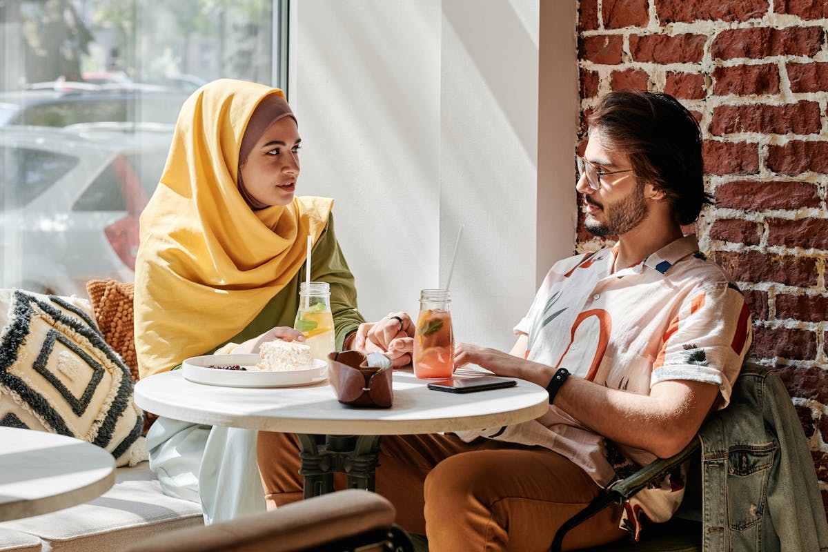 Coppia che si tiene per mano mentre mangia in un caffè accogliente