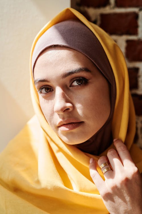 A Woman in Yellow Hijab Looking with a Serious Face