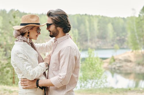 Free A couple sharing a romantic moment outdoors in a serene summer setting. Stock Photo