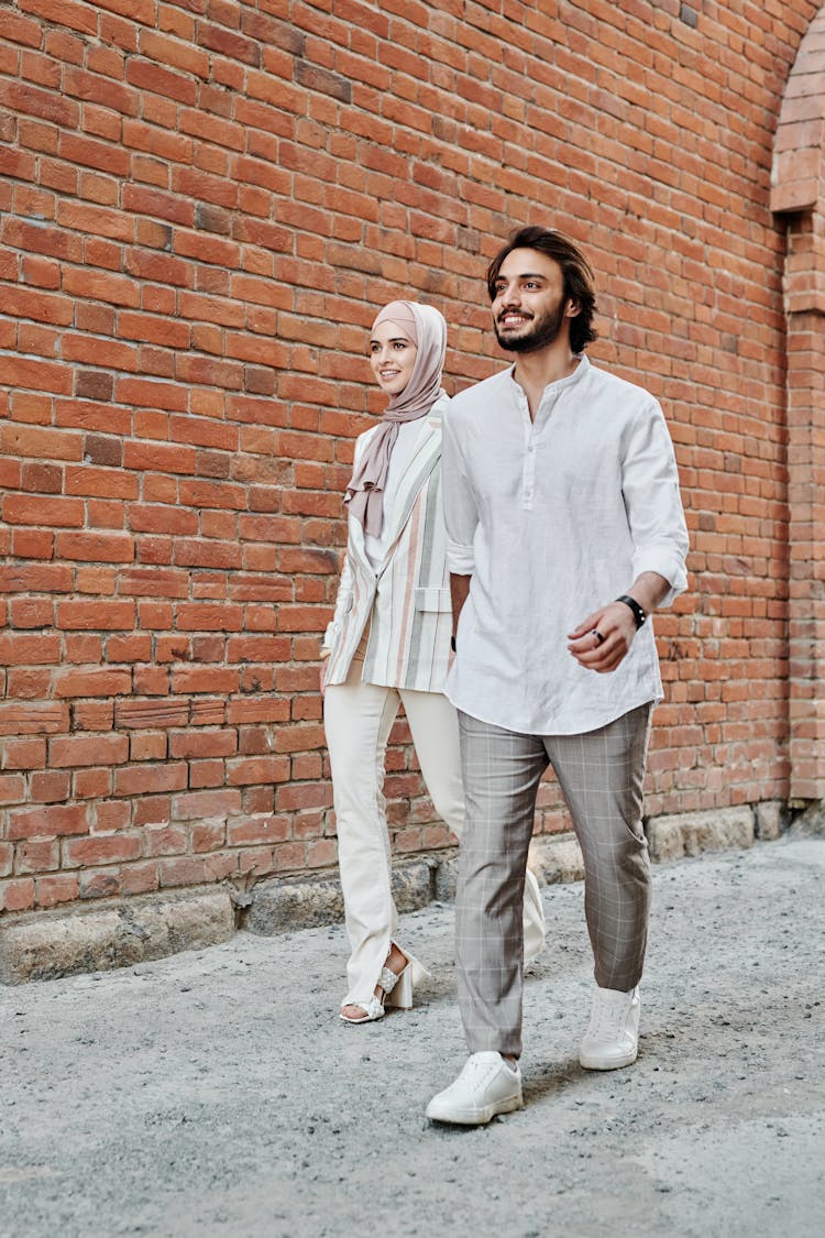 Bearded Man Walking With A Woman Near Brick Wall