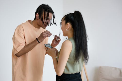 Woman Holding Cellphone While Talking to a Man