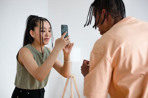 Free Woman Taking Picture of a Man on Her Smartphone Stock Photo