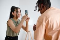 Woman in White Shirt Holding Smartphone