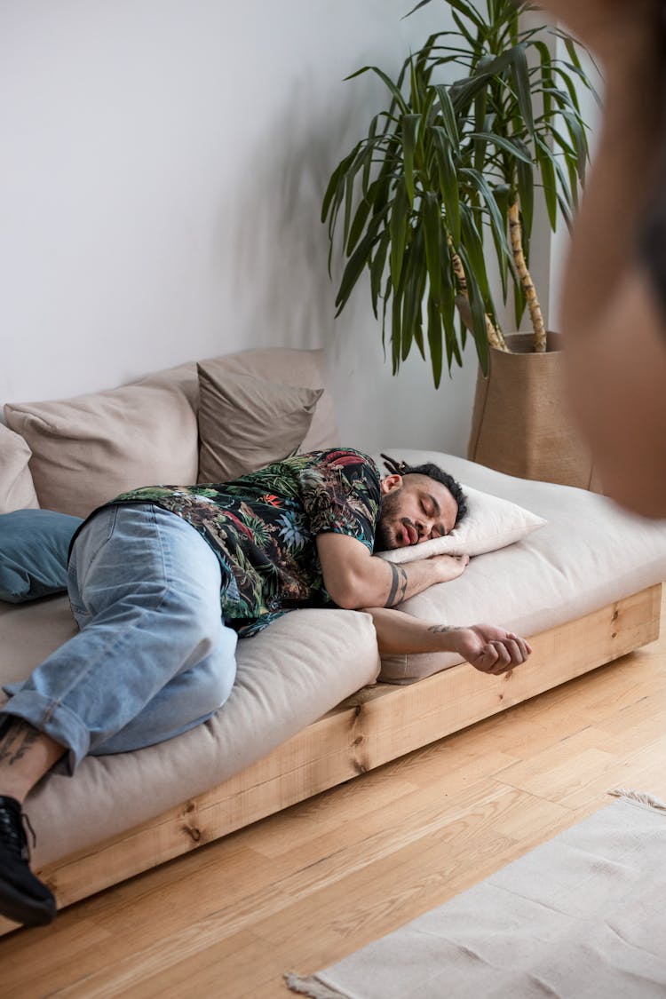 A Man Sleeping On A Sofa Bed